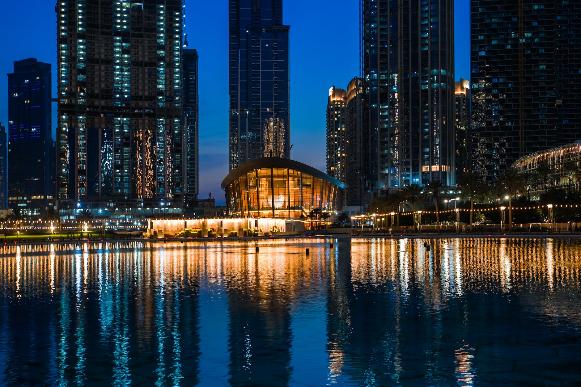 city skyline across body of water during night time